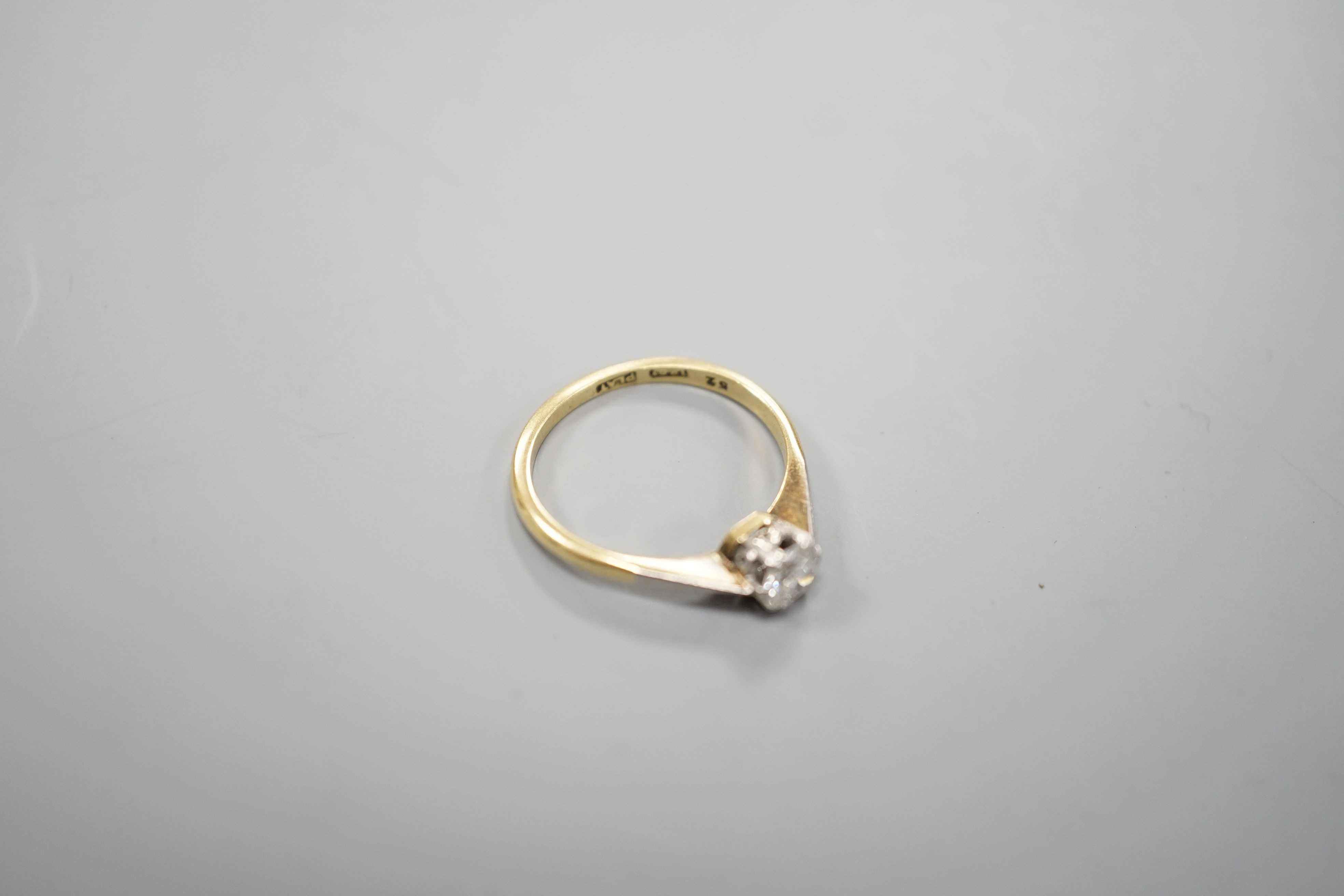 An 18ct gold and platinum solitaire diamond ring, the brilliant cut stone approximately 0.35cts, size M, gross 2.5 grams